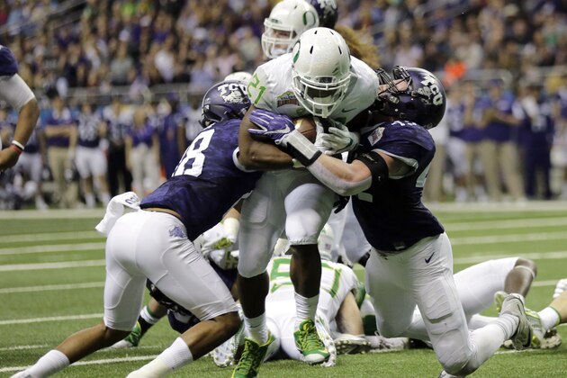 Oregon running back Royce Freeman (21) drives between TCU defenders Nick Orr (18) and Ty Summers (42) to score a touchdown during the first half of the Alamo Bowl NCAA college football game Saturday, Jan. 2, 2016, in San Antonio. (AP Photo/Eric Gay)