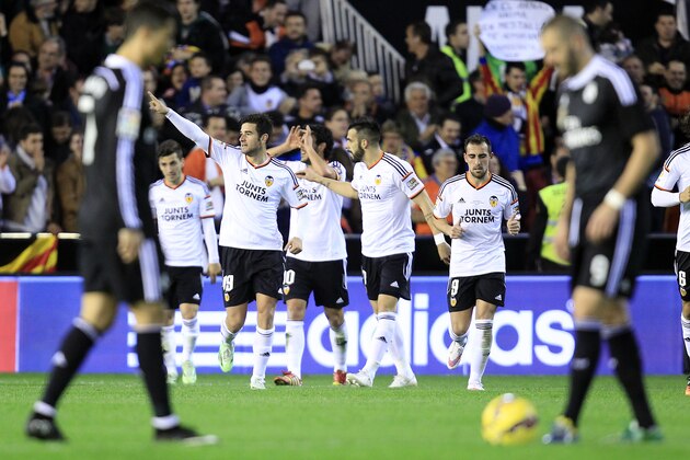 Valencia's Antonio Barragan, second left, celebrates after scoring against Real Madrid during a Spanish La Liga soccer match at the Mestalla stadium in Valencia, Spain, on Sunday, Jan. 4, 2015. (AP Photo/Alberto Saiz) is greeted by teammates