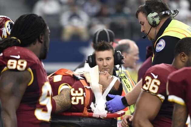 Washington Redskins' Dashaun Phillips (35) is carted off the field by first responders as Ricky Jean Francois (99) watches in the first half of an NFL football game against the Dallas Cowboys, Sunday, Jan. 3, 2016, in Arlington, Texas. Phillips was injured while helping stop Cowboys running back Darren McFadden on a running play. (AP Photo/Michael Ainsworth)