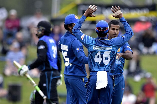 Jeffrey Vandersay (C) of Sri Lanka celebrates with teammates after Martin Guptill (back L) of New Zealand was caught with a leg before wicket (LBW) during the fourth one-day international cricket match between New Zealand and Sri Lanka at the Saxton Oval in Nelson on January 2, 2016.   AFP PHOTO / MARTY MELVILLE / AFP / Marty Melville        (Photo credit should read MARTY MELVILLE/AFP/Getty Images)
