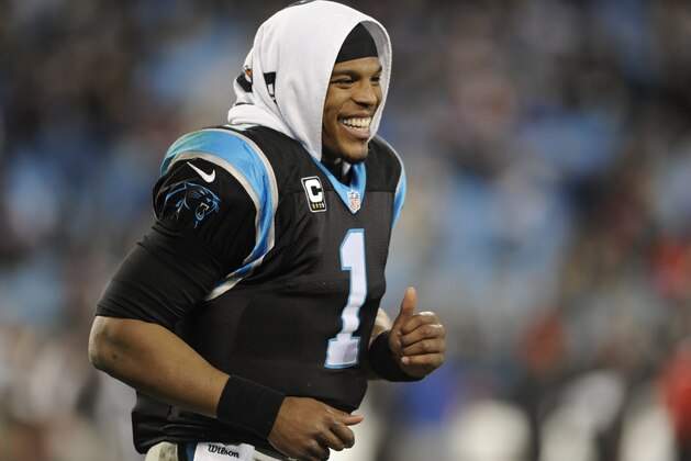 Carolina Panthers' Cam Newton (1) smiles as he runs down the bench area in the second half of an NFL football game against the Tampa Bay Buccaneers in Charlotte, N.C., Sunday, Jan. 3, 2016. (AP Photo/Mike McCarn)