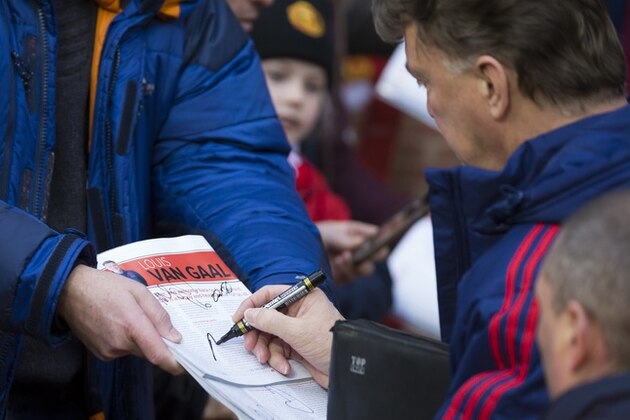 Manchester United's manager Louis van Gaal signs autographs for supporters before the English Premier League soccer match between Manchester United and Swansea City at Old Trafford Stadium, Manchester, England, Saturday, Jan. 2, 2016. (AP Photo/Jon Super)