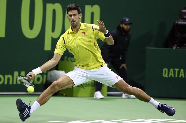 TOPSHOT - Novak Djokovic of Serbia returns the ball to Germany's Dustin Brown during their tennis match in the Qatar Open competition on January 4, 2016, in Doha. AFP PHOTO / KARIM JAAFAR / AFP / KARIM JAAFAR        (Photo credit should read KARIM JAAFAR/AFP/Getty Images)