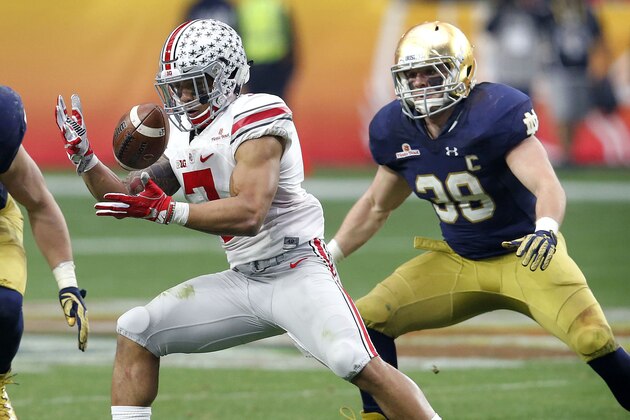 El running back Jalin Marshall (7), de Ohio State, trata de controlar el balón en medio de Joe Schmidt (38) y Jarrett Grace (59), de Notre Dame, en acciones de la segunda mitad del Fiesta Bowl el viernes 1 de enero de 2016, en Glendale, Arizona.  (AP Photo/Rick Scuteri)