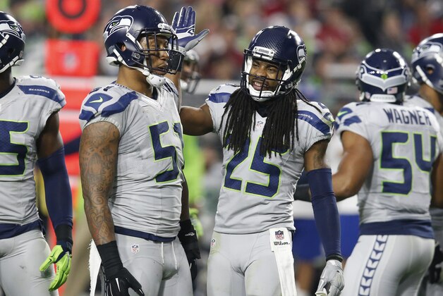 Seattle Seahawks cornerback Richard Sherman (25) celebrates a stop with outside linebacker Bruce Irvin (51) during the second half of an NFL football game against the Arizona Cardinals, Sunday, Jan. 3, 2016, in Glendale, Ariz. (AP Photo/Rick Scuteri)