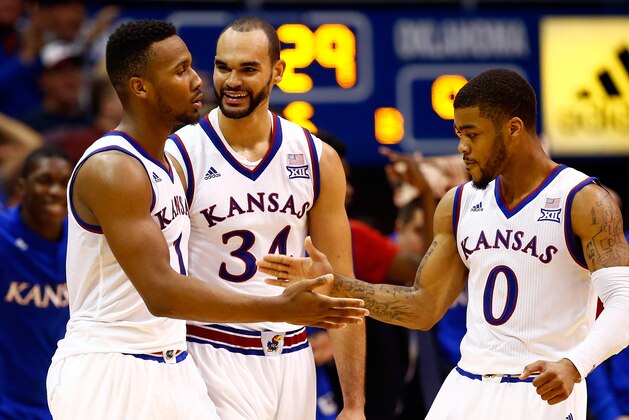 LAWRENCE, KS - JANUARY 04:  Wayne Selden Jr. #1 of the Kansas Jayhawks is congratulated by Perry Ellis #34 and Frank Mason III #0 after making a three-pointer and drawing a foul during the second overtime of the game against the Oklahoma Sooners game at Allen Fieldhouse on January 4, 2016 in Lawrence, Kansas.  The Jayhawks defeated the Sooners in triple overtime with a final score of 109-106 to win the game.  (Photo by Jamie Squire/Getty Images)