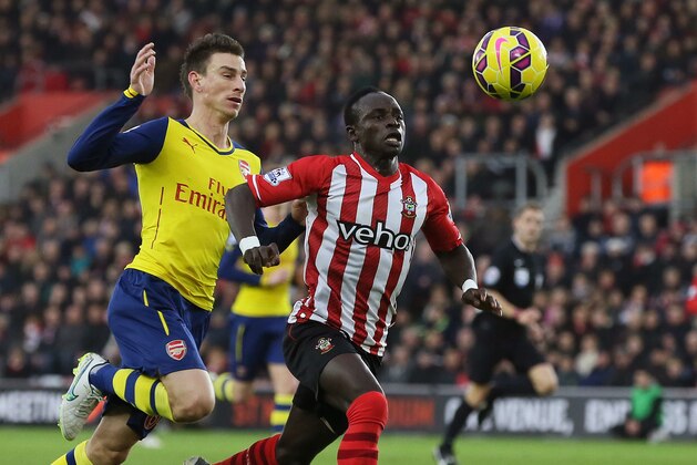 FILE-In this file photo taken on Thursday, Jan. 1, 2015, Southampton’s Sadio Mane, right, breaks away from Arsenal’s Laurent Koscielny to score a goal during the English Premier League soccer match between Southampton and Arsenal at St Mary's Stadium, Southampton, England. There will be no Didier Drogba and no Samuel Eto’o. For the first time in more than a decade, both of Africa’s most celebrated players will be missing from the African Cup of Nations after retiring from international soccer. It’s a chance for other players to make their mark at the continent’s top tournament. The question surrounding Sadio Mane is: will he play? Ruled out of the Cup of Nations with a leg injury by his English club Southampton, Senegal coach Alain Giresse has still picked Mane in his final squad in the hope that he will recover to play a part. Mane is a pivotal figure for a new-look Senegal team as an energetic midfielder with a habit of scoring valuable goals. (AP Photo/Tim Ireland, File)