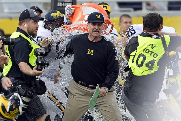 Jan 1, 2016; Orlando, FL, USA; Michigan Wolverines head coach Jim Harbaugh has water dumped on him after defeating Florida Gators to 41-7 to win the 2016 Citrus Bowl at Orlando Citrus Bowl Stadium. Michigan Wolverines defeated Florida Gators 41-7. Mandatory Credit: Tommy Gilligan-USA TODAY Sports