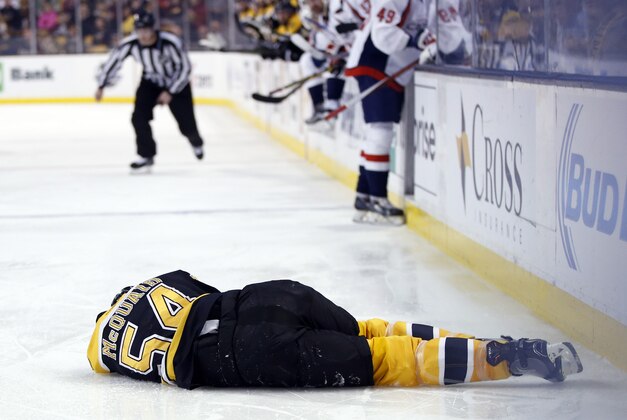 Jan 5, 2016; Boston, MA, USA; Boston Bruins defenseman Adam McQuaid (54) lies on the ice after being checked into the boards by Washington Capitals center Zach Sill (not pictured) during the second period at TD Garden. Mandatory Credit: Greg M. Cooper-USA TODAY Sports
