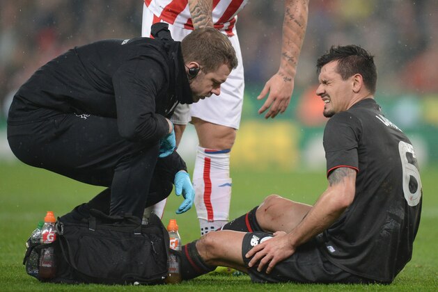 Liverpool's Croatian defender Dejan Lovren (R) receives treatment for an injury before being substituted in the first half during the English League Cup semi-final first leg football match at Britannia Stadium in Stoke-on-Trent, central England, on January 5, 2016.  AFP PHOTO / OLI SCARFF

RESTRICTED TO EDITORIAL USE. No use with unauthorized audio, video, data, fixture lists, club/league logos or 'live' services. Online in-match use limited to 75 images, no video emulation. No use in betting, games or single club/league/player publications. / AFP / OLI SCARFF        (Photo credit should read OLI SCARFF/AFP/Getty Images)