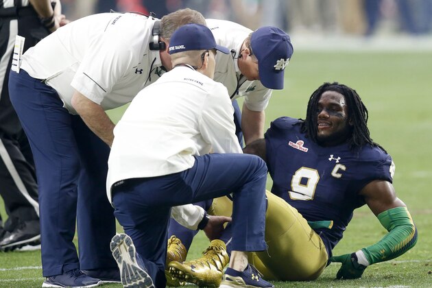 Notre Dame linebacker Jaylon Smith (9) is attended to after being injured against Ohio State during the first half of the Fiesta Bowl NCAA College football game, Friday, Jan. 1, 2016, in Glendale, Ariz.  (AP Photo/Rick Scuteri)