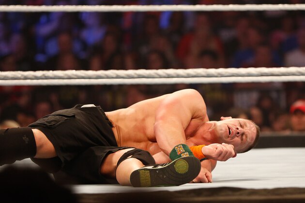 NEW YORK, NY - AUGUST 23:  John Cena recovers from a blow during his fight against Seth Rollins at the WWE SummerSlam 2015 at Barclays Center of Brooklyn on August 23, 2015 in New York City.  (Photo by JP Yim/Getty Images)