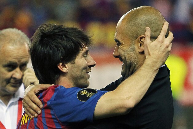 FC Barcelona's Lionel Messi from Argentina, left,  celebrates his victory with coach Josep Guardiola during the final Copa del Rey  soccer match against Athletic Bilbao at the Vicente Calderon stadium in Madrid, Spain, Friday, May 25, 2012. (AP Photo/Andres Kudacki)