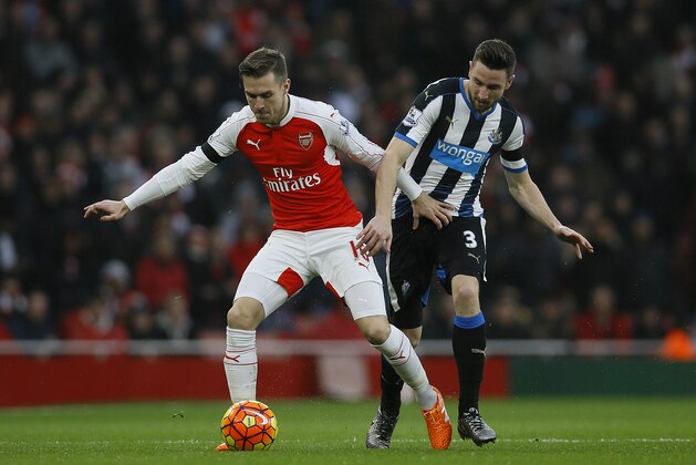 Arsenal's Aaron Ramsey, left, competes for the ball with Newcastle United's Paul Dummett during the English Premier League soccer match between Arsenal and Newcastle United at Emirates stadium in London, Saturday, Jan. 2, 2016. (AP Photo/Kirsty Wigglesworth)