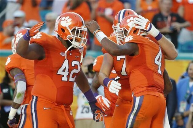 FILE - In this Thursday, Dec. 31, 2015, file photo, Clemson quarterback Deshaun Watson (4) is congratulated by linemen Christian Wilkins (42) and Mitch Hyatt (75) after Watson scored a touchdown during the first half of the Orange Bowl NCAA college football semifinal playoff game against Oklahoma, in Miami Gardens, Fla. Clemson's offensive line has conquered challenges all season. Its final, and perhaps biggest, will come in the national championship game against Alabama's dominating defense.  (AP Photo/Lynne Sladky, File)