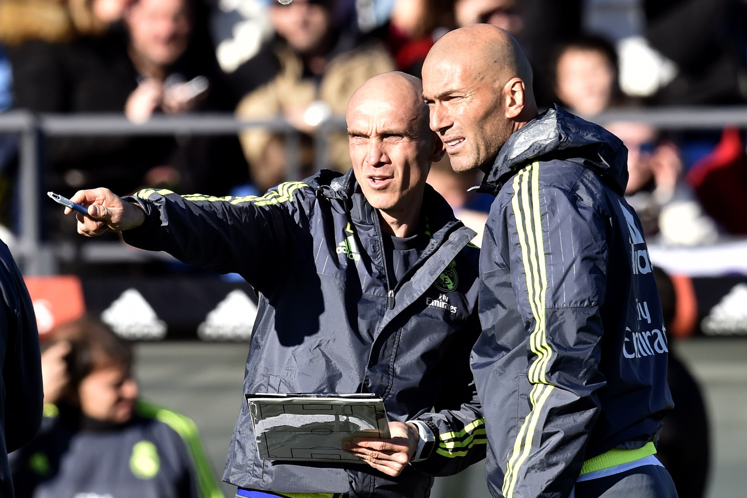 Real Madrid's new French coach Zinedine Zidane (R) listens to his French assistant coach David Bettoni during his first training session as coach of Real Madrid at the Alfredo di Stefano Stadium in Valdebebas, on the outskirts of Madrid, on January 5, 2016. Real Madrid legend Zinedine Zidane promised to put his 'heart and soul' into managing the Spanish giants after he was sensationally named as coach following Rafael Benitez's unceremonious sacking.   AFP PHOTO/ GERARD JULIEN / AFP / GERARD JULIEN        (Photo credit should read GERARD JULIEN/AFP/Getty Images)