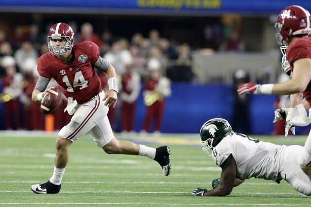 Alabama quarterback Jake Coker (14) escapes the grasp of Michigan State defensive lineman Lawrence Thomas (8) during the first half of the Cotton Bowl NCAA college football semifinal playoff game, Thursday, Dec. 31, 2015, in Arlington, Texas. (AP Photo/LM Otero)