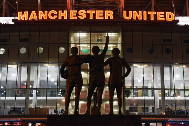 A general view outside Old Trafford stadium and 'The United Trinity' statue of former Manchester United players George Best, Denis Law, and Bobby Charlton seen ahead of the English Premier League football match between Manchester United and Burnley at Old Trafford in Manchester, north west England, on February 11, 2015.  AFP PHOTO / OLI SCARFFRESTRICTED TO EDITORIAL USE. No use with unauthorized audio, video, data, fixture lists, club/league logos or live services. Online in-match use limited to 45 images, no video emulation. No use in betting, games or single club/league/player publications.        (Photo credit should read OLI SCARFF/AFP/Getty Images)