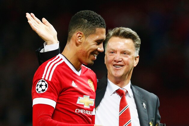MANCHESTER, ENGLAND - SEPTEMBER 30:  Louis van Gaal manager of Manchester United celebrates victory with winning goalscorer Chris Smalling in the UEFA Champions League Group B match between Manchester United FC and VfL Wolfsburg at Old Trafford on September 30, 2015 in Manchester, United Kingdom.  (Photo by Dean Mouhtaropoulos/Getty Images)