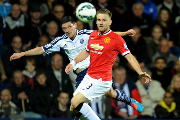 West Brom's Graham Dorrans, left, crosses the ball past Manchester United's Luke Shaw during the English Premier League soccer match between West Bromwich Albion and Manchester United at the Hawthorns, Birmingham, England, Monday, Oct. 20, 2014. (AP Photo/Rui Vieira)