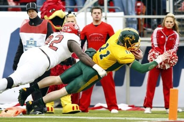 North Dakota State quarterback Carson Wentz (11) dives for a touchdown as Jacksonville State defensive lineman Desmond Owino (92) is unable to make the tackle during the first half of the FCS championship NCAA college football game, Saturday, Jan. 9, 2016, in Frisco, Texas.  (AP Photo/Mike Stone)