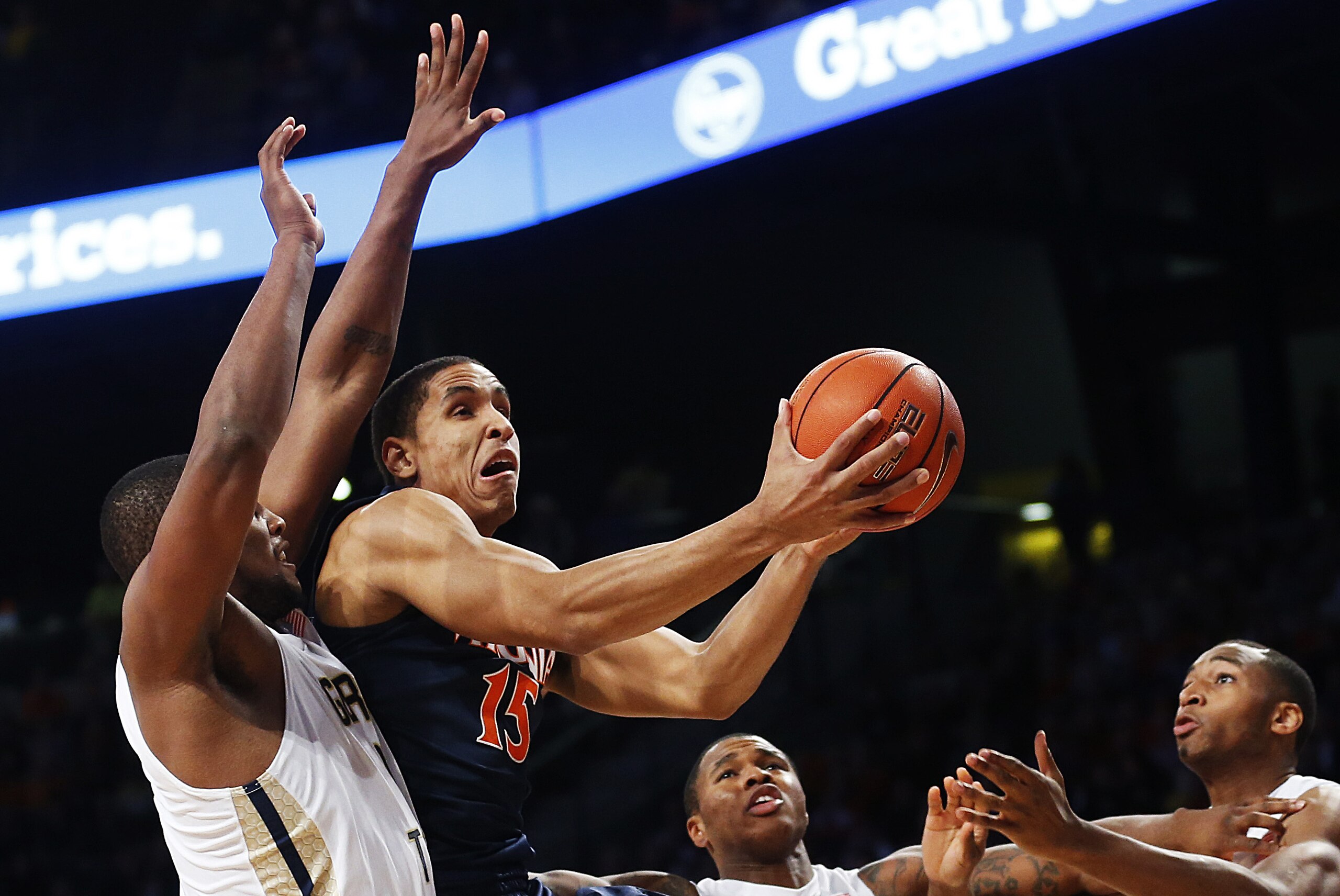 Virginia's Malcolm Brogdon (15) puts up a shot against Georgia Tech's Charles Mitchell, from left, Marcus Georges-Hunt, and James White in the first half of an NCAA college basketball game Saturday, Jan. 9, 2016, in Atlanta. (AP Photo/David Goldman)