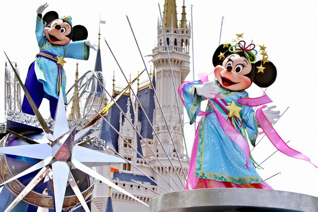 TOKYO, JAPAN:  (FILES) Dated 01 July 2004 filed photo shows Mickey and Minnie Mouse, who play Altair the Cowherd and Vega the Weaver, wave to spectators from the float to celebrate Tanabata or the Star Festival at the Tokyo Disneyland. Asia already hosts half of the world's top 10 most visited parks, with the 10 biggest attractions in the region luring 68 million visitors a year, as report said 18 July, 2004.  AFP PHOTO/Yoshikazu TSUNO  (Photo credit should read YOSHIKAZU TSUNO/AFP/Getty Images)