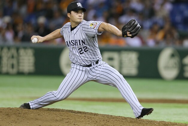 This picture taken on April 3, 2015 shows South Korean pitcher Oh Seung-Hwan of the Hanshin Tigers in the Nippon Professional Baseball league throwing against the Yomiuri Giants at the Tokyo Dome. The star South Korean pitcher pursuing a US major league baseball contract was grilled by prosecutors on December 9, 2015 over allegations that he illegally gambled overseas.      JAPAN OUT       AFP PHOTO / JIJI PRESS / AFP / JIJI PRESS / JIJI PRESS        (Photo credit should read JIJI PRESS/AFP/Getty Images)