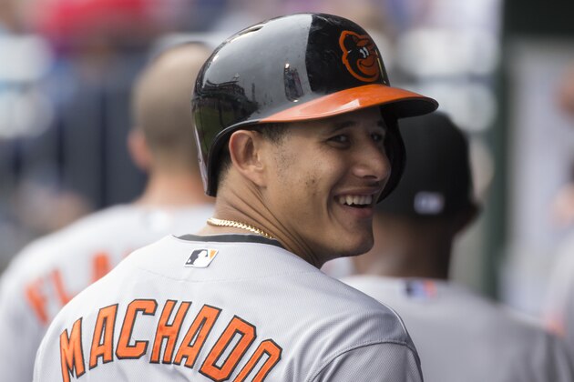 Baltimore Orioles' Manny Machado looks back with a smile while in the dugout during the fifth inning of a baseball game against the Philadelphia Phillies, Thursday, June 18, 2015, in Philadelphia. (AP Photo/Chris Szagola)