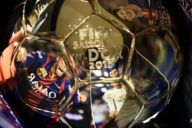 TOPSHOT - A picture taken on December 15, 2015 shows (From L) images of Barcelona's Brazilian forward Neymar, Real Madrid's Portuguese forward Cristiano Ronaldo and  Barcelona's Argentinian forward Lionel Messi, reflecting into the Ballon d'Or 2015 trophy displayed at the Mellerio jewelery workshops in Paris.The Ballon d'Or 2015, Fifa's annual football award given to the male player considered to have performed the best in the previous calendar year, will be awarded on January 11, 2016 during a gala event in Zurich. / AFP / FRANCK FIFE        (Photo credit should read FRANCK FIFE/AFP/Getty Images)