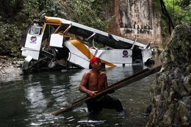 A passenger bus lays in a ravine after falling off the road in Atoyac, Veracruz state, Mexico, Sunday, Jan. 10, 2016. The bus, belonging to the Paso del Toro line, was carrying members of a football team and their relatives along the road connecting the cities of Camaron and Cordoba. According to authorities, at least 20 people were killed and 25 were injured. (AP Photo/Felix Marquez)