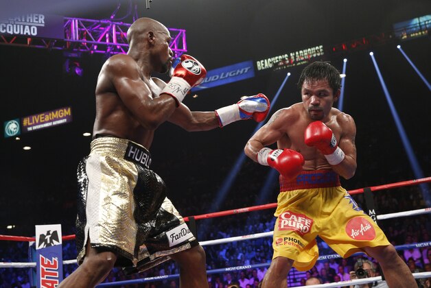 Floyd Mayweather Jr. exchange punches with Manny Pacquiao during their welterweight unification championship bout, May 2, 2015 at MGM Grand Garden Arena in Las Vegas, Nevada.  Mayweather defeated Pacquiao by unanimous decision.  AFP PHOTO / JOHN GURZINKSI        (Photo credit should read JOHN GURZINSKI/AFP/Getty Images)
