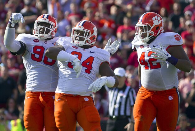 Nov 28, 2015; Columbia, SC, USA; Clemson Tigers defensive end Shaq Lawson (90), tight end Cannon Smith (84), and defensive lineman Christian Wilkins (42) celebrate after the play during the first half against the South Carolina Gamecocks at Williams-Brice Stadium. Mandatory Credit: Joshua S. Kelly-USA TODAY Sports