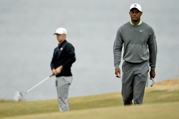 FILE - In this June 16, 1995, file photo, Tiger Woods, right, walks to the fifth green as Jordan Spieth chips during a practice round for the U.S. Open golf tournament at Chambers Bay in University Place, Wash. When Woods turned pro at 20, the No. 1 player in the world was 41-year-old Greg Norman. Woods is 40, and the No. 1 player is 22-year-old Spieth. (AP Photo/Charlie Riedel, File)