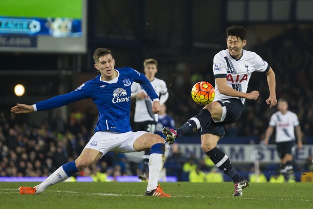 Everton's John Stones, left, fights for the ball against Tottenham's Son Heung-Min during the English Premier League soccer match between Everton and Tottenham at Goodison Park Stadium, Liverpool, England, Sunday Jan. 3,  2016. (AP Photo/Jon Super)
