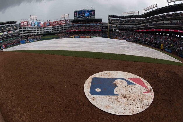 Jun 13, 2015; Arlington, TX, USA; A view of the MLB logo and on deck circle and covered field during a rain delay in the game between the Texas Rangers and the Minnesota Twins at Globe Life Park in Arlington. The Rangers defeated the Twins 11-7. Mandatory Credit: Jerome Miron-USA TODAY Sports