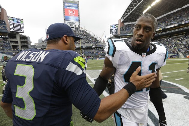 Seattle Seahawks quarterback Russell Wilson (3) greets Carolina Panthers strong safety Roman Harper, right, after an NFL football game, Sunday, Oct. 18, 2015, in Seattle. The Panthers beat the Seahawks 27-23. (AP Photo/Elaine Thompson)