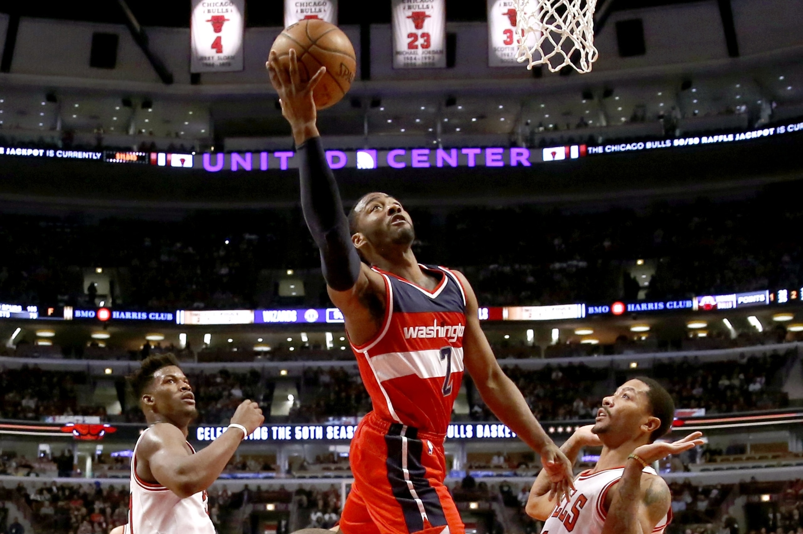 Washington Wizards guard John Wall (2) scores between the defense of Chicago Bulls guard Jimmy Butler, left, and Derrick Rose during the second half of an NBA basketball game, Monday, Jan. 11, 2016, in Chicago. The Wizards won 114-100. (AP Photo/Charles Rex Arbogast)