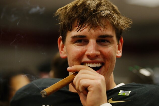 GLENDALE, AZ - JANUARY 11:  Jake Coker #14 of the Alabama Crimson Tide celebrates by smoking a cigar after defeating the Clemson Tigers 45-40 in the 2016 College Football Playoff National Championship Game at University of Phoenix Stadium on January 11, 2016 in Glendale, Arizona.  The Crimson Tide defeated the Tigers with a score of 45 to 40.  (Photo by Kevin C. Cox/Getty Images)