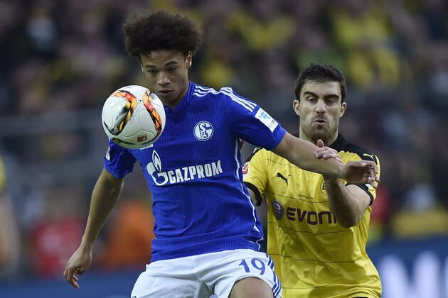 Schalke's Leroy Sane, left, and Dortmund's Sokratis challenge for the ball during the German Bundesliga soccer match between Borussia Dortmund and FC Schalke 04 in Dortmund, Germany, Sunday, Nov. 8, 2015. (AP Photo/Martin Meissner)