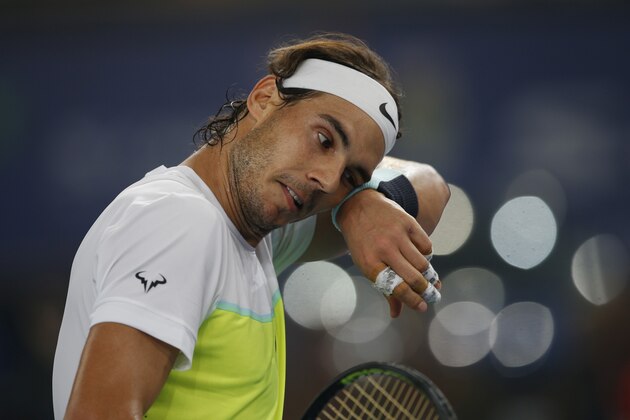 Rafael Nadal of Indian Aces wipes the sweat from his face as he plays Roger Federer of UAE Royals in the men's singles event of the International Premier Tennis League in New Delhi, India, Saturday, Dec. 12, 2015. (AP Photo /Tsering Topgyal)