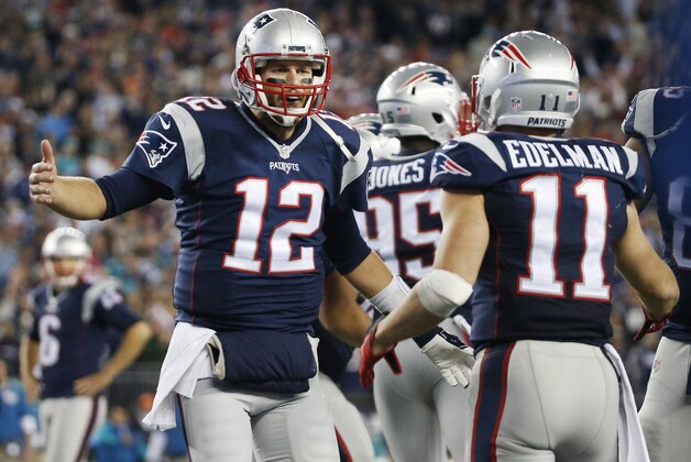New England Patriots quarterback Tom Brady (12) celebrates his touchdown pass to wide receiver Julian Edelman (11) in the second half of an NFL football game against the Miami Dolphins, Thursday, Oct. 29, 2015, in Foxborough, Mass. (AP Photo/Michael Dwyer)