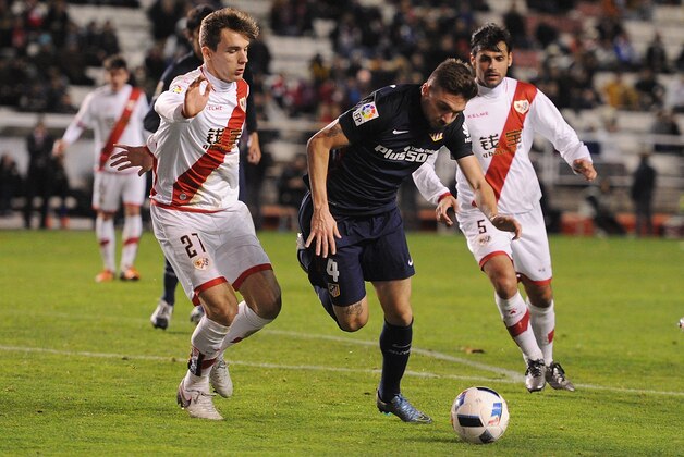 MADRID, SPAIN - JANUARY 06:   Guilherme Siqueira of Club Atletico de Madrid tries to beat Diego Llorente of Rayo Vallecano de Madrid during the Copa del Rey, Round of 16 First Leg match, between Rayo Vallecano de Madrid and Club Atletico de Madrid at Estadio de Vallecas on January 6, 2016 in Madrid, Spain.  (Photo by Denis Doyle/Getty Images)