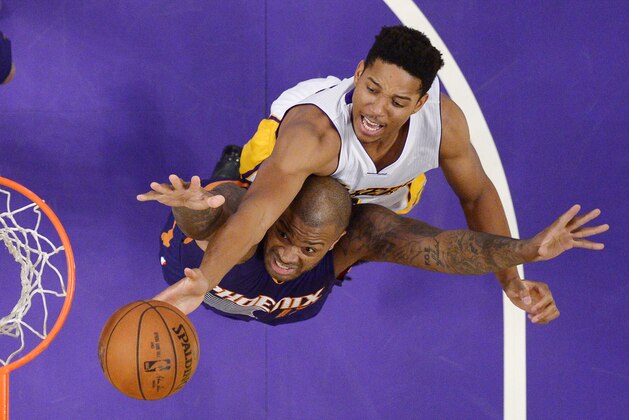 Phoenix Suns forward P.J. Tucker, below, and Los Angeles Lakers forward Anthony Brown reach for a rebound during the first half of an NBA basketball game Sunday, Jan. 3, 2016, in Los Angeles. (AP Photo/Mark J. Terrill)