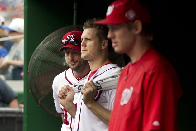 From left to right, Washington Nationals pitchers Max Scherzer, Jonathan Papelbon and Stephen Strasburg watch the eighth inning of a baseball game against the Philadelphia Phillies at Nationals Park in Washington, Sunday, Sept. 27, 2015, after Papelbon got into a dugout fight with teammate Bryce Harper during the inning. The Phillies won 12-5. (AP Photo/Jacquelyn Martin)