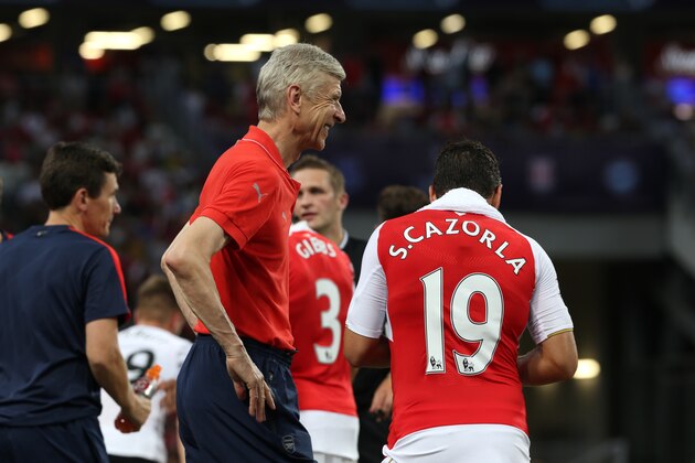 SINGAPORE - JULY 18:  Arsene Wenger of Arsenal smiles at Santi Cazorla of Arsenal during the Barclays Asia Trophy match between Arsenal and Everton at the National Stadium on July 18, 2015 in Singapore.  (Photo by Lionel Ng/Getty Images)