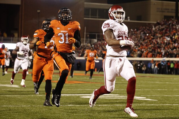 STILLWATER, OK - NOVEMBER 28 : Running back Joe Mixon #25 of the Oklahoma Sooners scores with safety Tre Flowers #31 of the Oklahoma State Cowboys in pursuit November 28, 2015 at Boone Pickens Stadium in Stillwater, Oklahoma. Oklahoma defeated Oklahoma State 58-23.(Photo by Brett Deering/Getty Images)