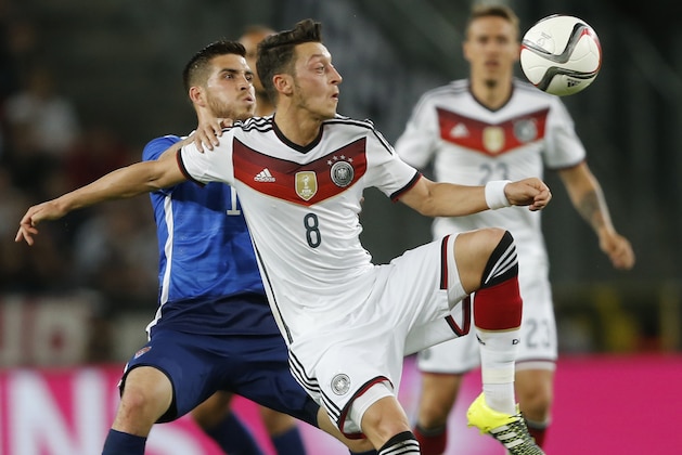 United States' Ventura Alvarado, left, Germany's Mesut Ozil challenge for the ball during the soccer friendly match between Germany and the United States in Cologne, western Germany, Wednesday, June 10, 2015. (AP Photo/Frank Augstein)