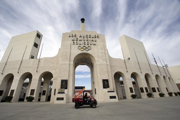 A worker rides past the entrance of The Los Angeles Memorial Coliseum on Wednesday, Jan. 13, 2016. NFL owners voted Tuesday night to allow the St. Louis Rams to move to a new stadium just outside Los Angeles. The Rams, based in the LA area from 1946-94, will play in a temporary facility, probably the Los Angeles Coliseum, until the new stadium is ready, most likely for the 2019 season. (AP Photo/Nick Ut)