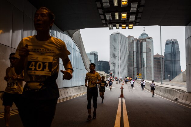 Competitors run through an underpass during Hong Kong's first inner city ultra marathon on March 1, 2015. Hundreds of runners competed in Hong Kong's first inner city ultra marathon on March 1 despite a repetitive two-kilometre course which has been criticised as simply too boring. AFP PHOTO / ANTHONY WALLACE        (Photo credit should read ANTHONY WALLACE/AFP/Getty Images)